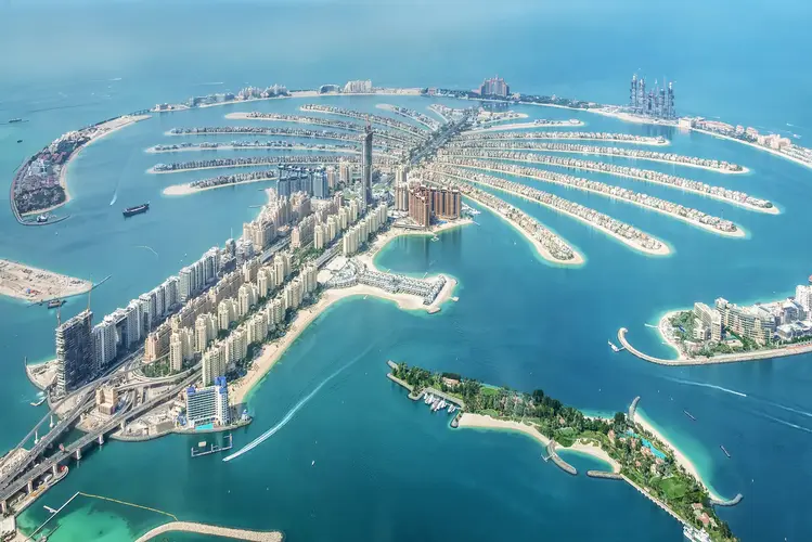 Aerofoto skats uz mākslīgo salu Palm Jumeirah Dubaijā, kas veidota palmas koka formā un kuru ieskauj zils ūdens.